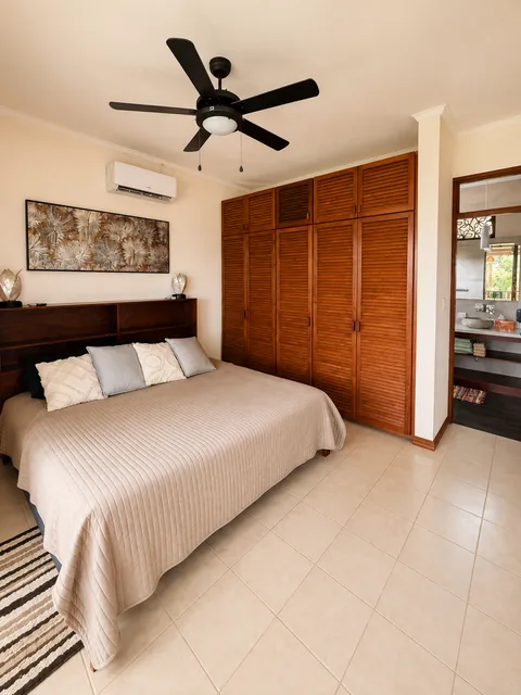 King bedroom with a built-in wood wardrobe and en-suite bathroom entrance