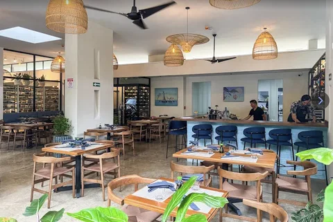 Momento Wine & Sushi Bar’s modern dining room with rattan pendant lights and a wine display wall