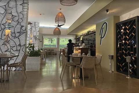 Potz Bistro’s dining room with a wine wall and rattan pendant lighting