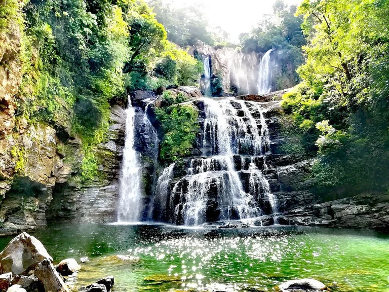 The dramatic multi-tiered Nauyaca Waterfalls cascading into a green jungle pool