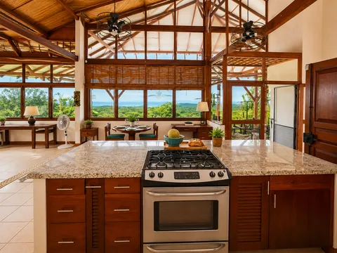Kitchen island and gas range looking out toward windows framing the Pacific Ocean