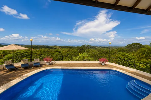 Low-angle view of the pool's vivid blue tile, with loungers and steps into the water